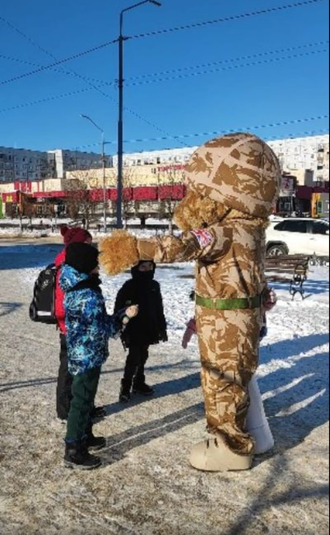 Bear mascot with Ukrainian children in the snow