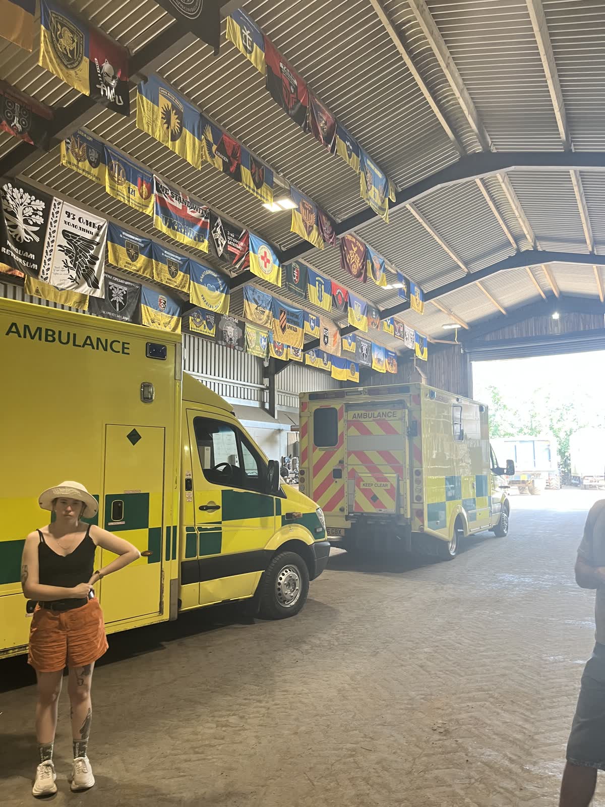Convoy ambulances parked inside the barn under the brigade banners