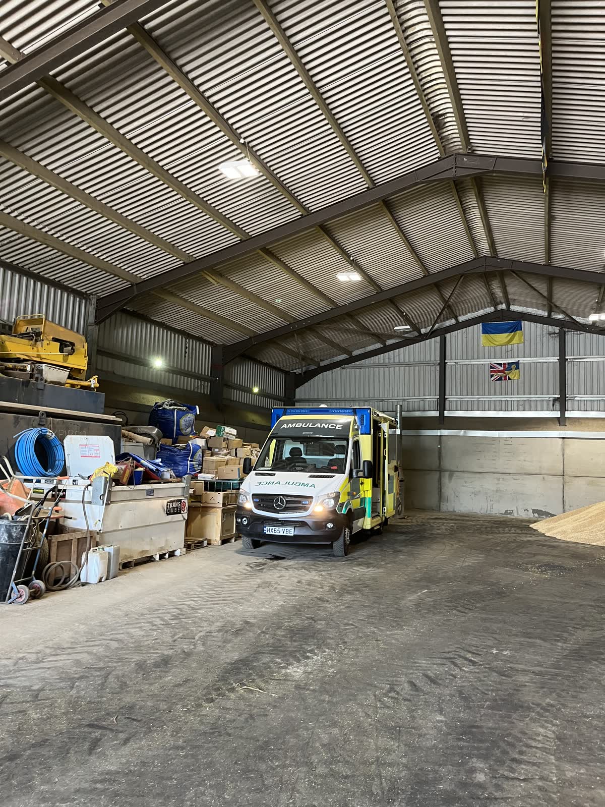 Inside the loading barn with a vehicle and stacked supplies