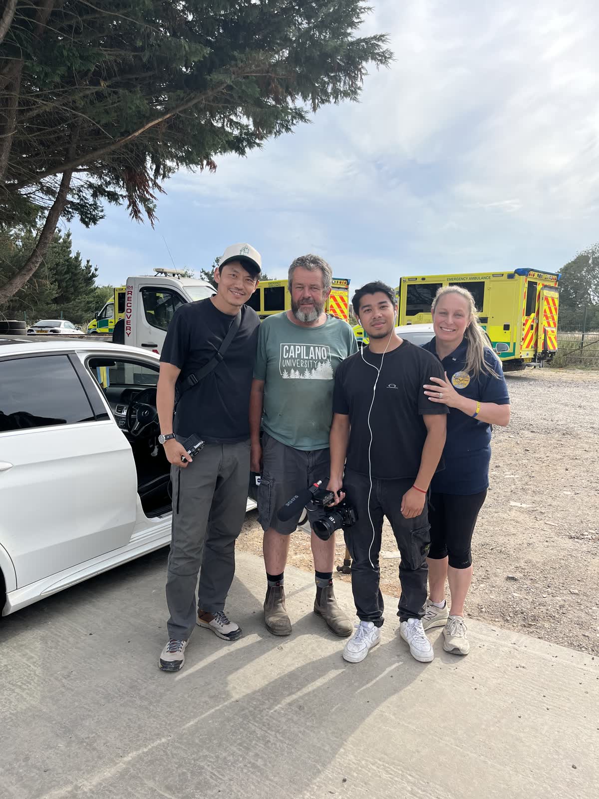 Four volunteer crew members standing together beside the convoy vehicles