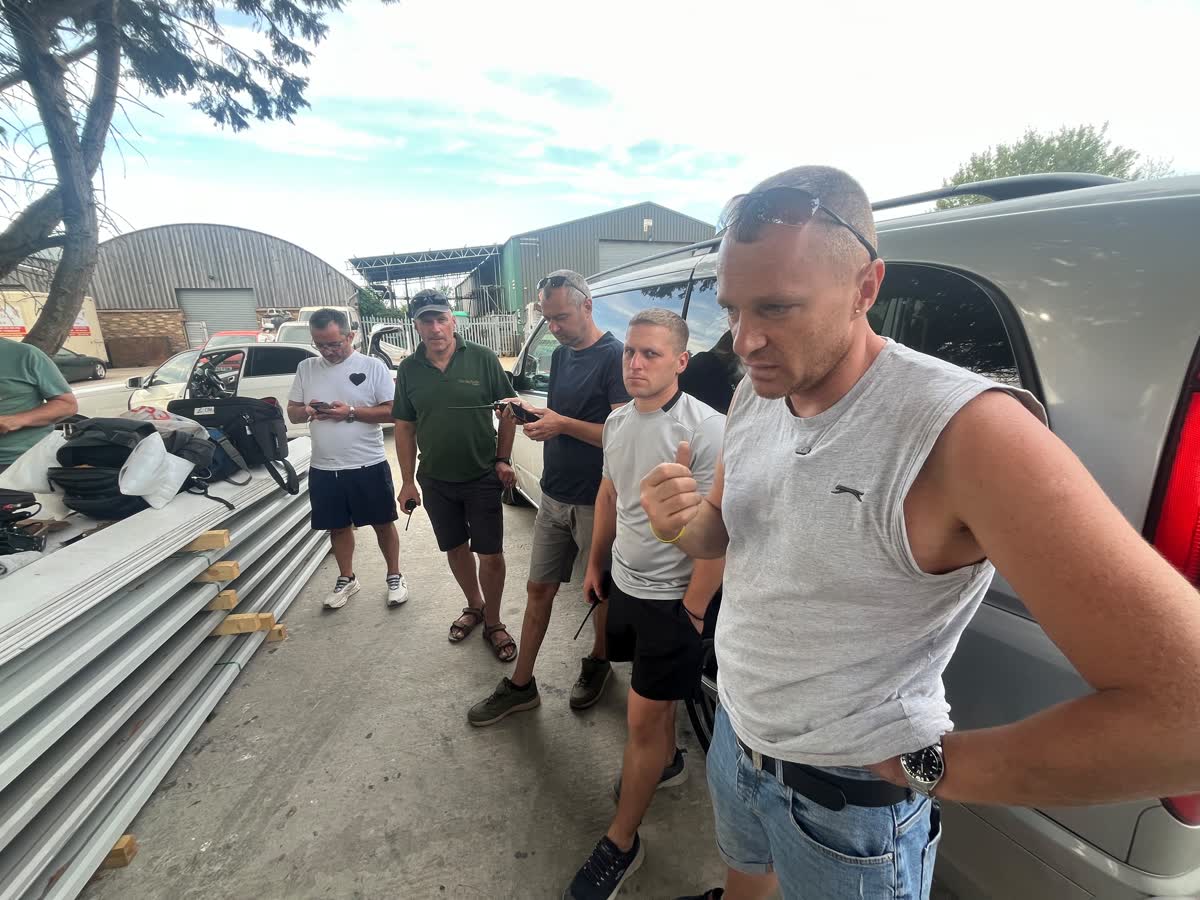Volunteer crew standing together on the farm yard beside the vehicles