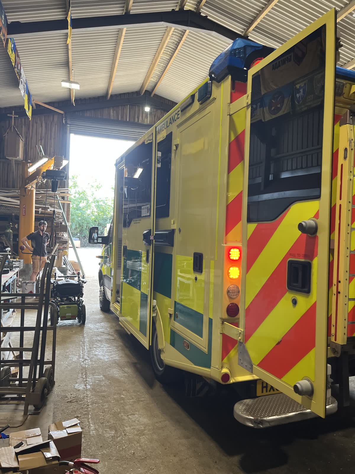 The rear of an ambulance being loaded with boxes of aid