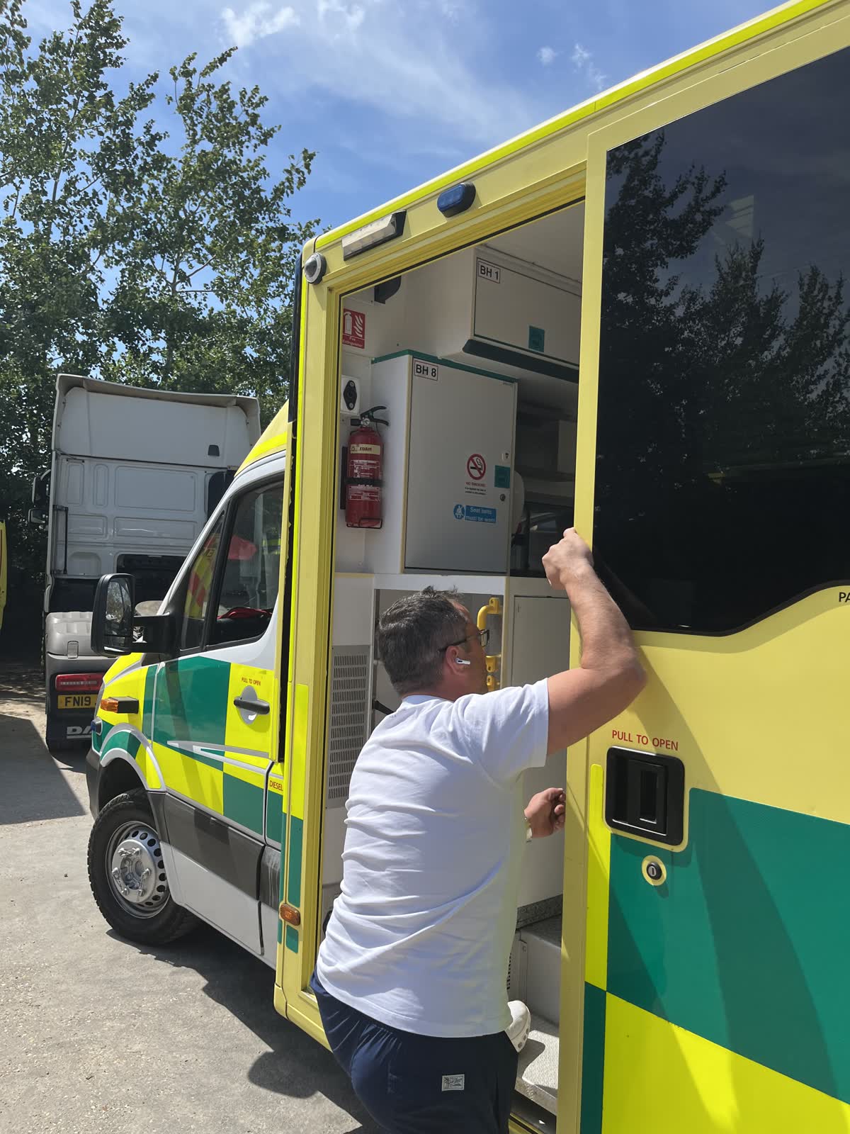 A volunteer loading supplies through the side door of an ambulance