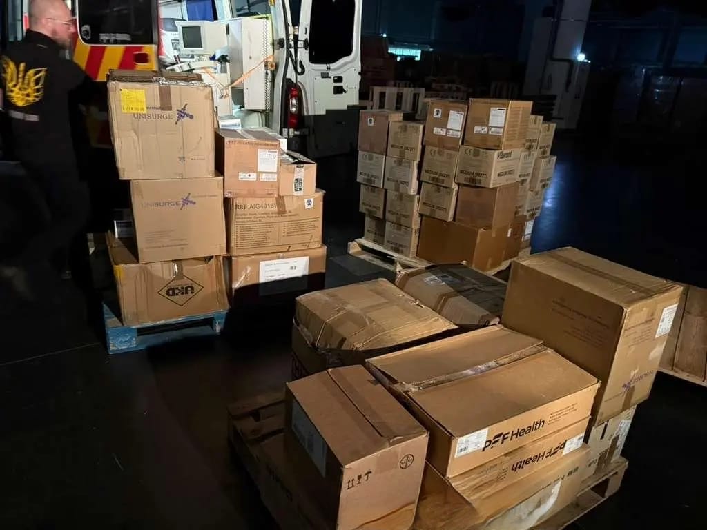 Pallets of medical supply boxes being loaded at night for dispatch to Ukraine